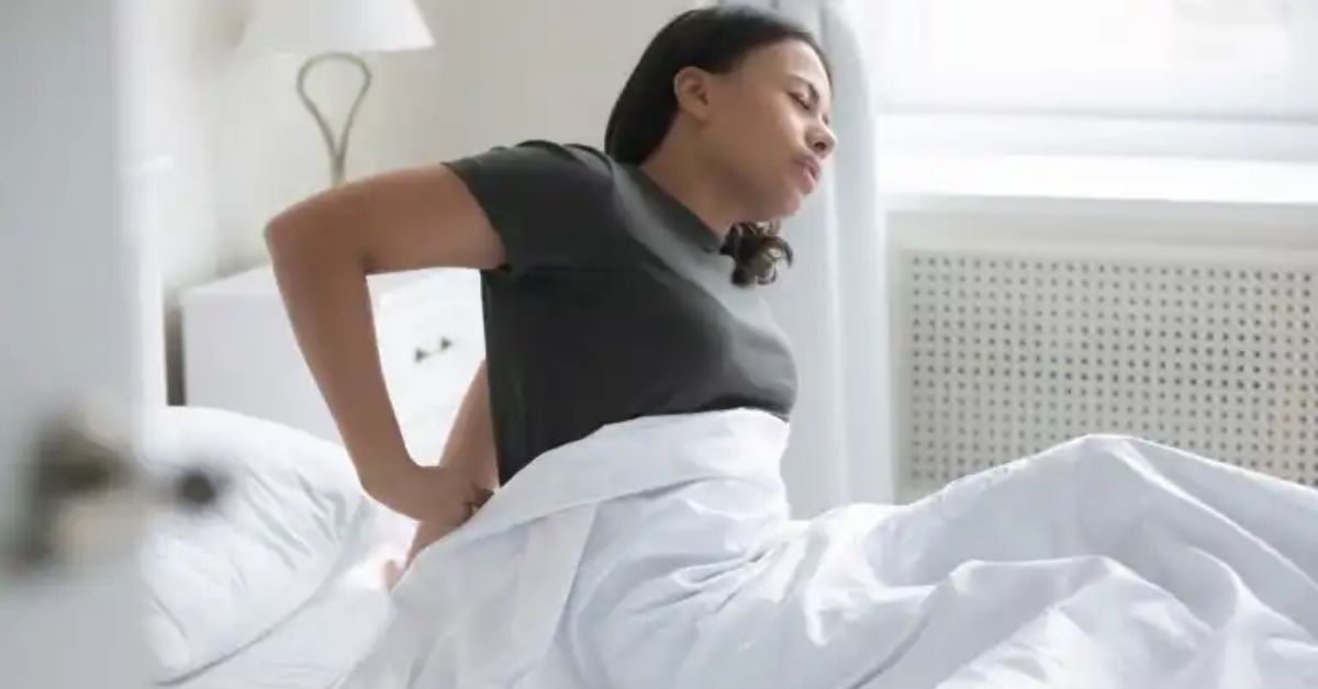 donna sul letto che tocca i reni